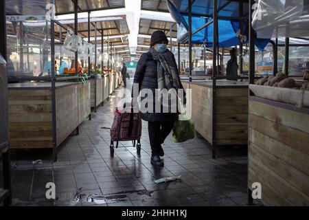 Belgrad, Serbien, 23. Januar 2022: Frau mit Einkaufskassewagen und Gesichtsmaske, die auf dem Marktplatz in Zemun herumläuft Stockfoto