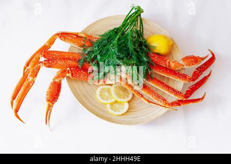 Krabben, Zitrone und Dill auf einer Platte auf einem weißen Hintergrund. Stockfoto