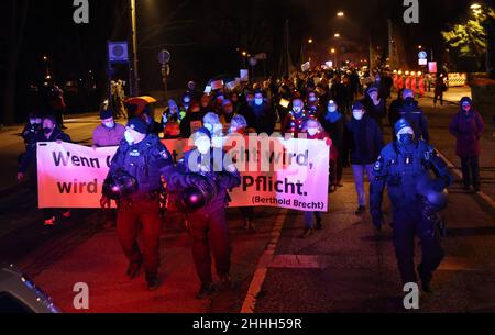 24. Januar 2022, Schleswig-Holstein, Lübeck: Polizeibeamte begleiten Demonstranten in Lübeck. Die Demonstranten tragen ein Transparent mit der Aufschrift: "Wenn Ungerechtigkeit richtig wird, wird Widerstand zur Pflicht" während einer Demonstration gegen die Maßnahmen von Corona. Foto: Christian Charisius/dpa Stockfoto