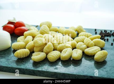 Küchentisch mit frischen Gnocchi zum Kochen Stockfoto