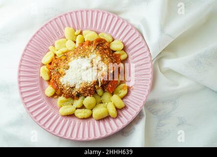Teller mit frischer Gnocchi mit Tomatensauce und geriebenem Parmesankäse Stockfoto