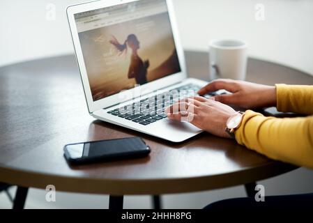 Ich werde dies definitiv veröffentlichen. Eine kurze Aufnahme einer unkenntlichen Frau, die allein sitzt und ihren Laptop zu Hause benutzt. Stockfoto