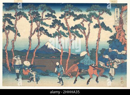 Hodogaya auf dem Tōkaidō (Tōkaidō Hodogaya), aus der Serie sechsunddreißig Ansichten des Fuji-Berges (Fugaku sanjūrokkei) ca. 1830–32 Katsushika Hokusai die japanische Hodogaya, eine der bekannten 53 Stationen der Tōkaidō-Straße, liegt zwischen Musashi, der Provinz, in der sich Edo befand, und der Provinz Sagami im Westen. An diesem Punkt sollen Reisende nach Westen endlich das Gefühl gespürt haben, die Metropole Edo hinter sich zu haben, denn bei Hodogaya erstreckt sich die Straße in eine wunderschöne Allee, die von Pinien auf beiden Seiten gesäumt ist. Wenn man zu Fuß einen Kurs in der Nähe eines Bi entlang fährt Stockfoto