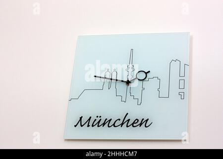 Eingangshalle im Hotelzimmer, eine quadratische Wanduhr, weißes mattes Glas, mit einem Designbild der Silhouette der Stadt und der Inschrift Stockfoto