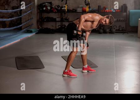 Junger Mann, der im Fitnessstudio Sport macht Stockfoto