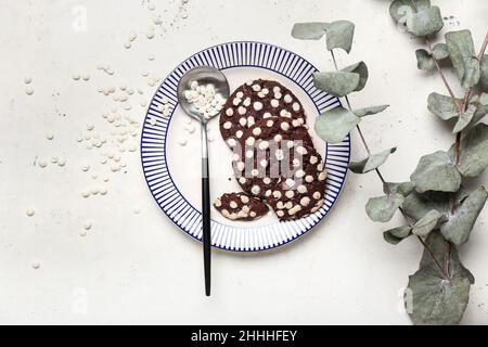 Teller mit leckeren Cookies mit weißen Schokoladenstückchen auf hellem Hintergrund Stockfoto