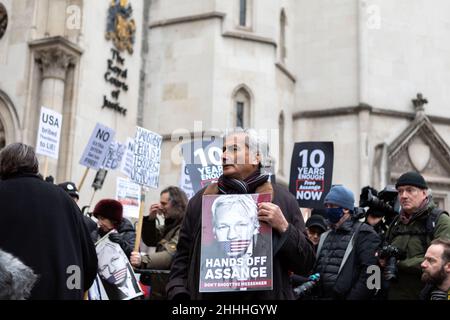 London, Großbritannien, 24/01/2022, Ein Protestler sah ein Plakat mit der Aufschrift "Hände weg von Assange. Schieß nicht auf den Boten'.der britische Oberste Gerichtshof hat Julian Assange die Erlaubnis erteilt, seine Berufung beim Obersten Gerichtshof des Vereinigten Königreichs einzulegen, weil der Fall wichtige rechtliche Aspekte aufwarf, die für die breite Öffentlichkeit von rechtlicher Bedeutung sind. Stella Moris, die Verlobte von Julian Assange, erschien vor den königlichen Gerichtshöfen, um eine Erklärung abzugeben, in der die jüngste Entscheidung bekanntgegeben wurde. Im Dezember 2021 entschied der Oberste Gerichtshof, dass Assange an die USA ausgeliefert werden kann, wo er verschiedene Verbrechen gemäß dem Spionagegesetz angeklagt wurde. Stockfoto