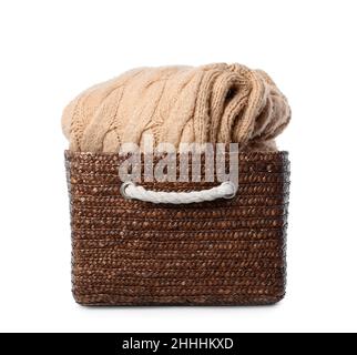 Weidenkorb mit warmem Strickpullover auf weißem Hintergrund Stockfoto