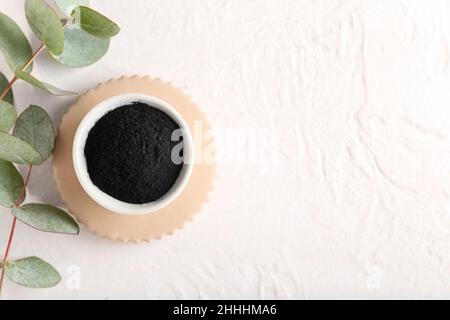 Schale mit aktivem Holzkohle-Zahnpulver auf weißem Hintergrund Stockfoto