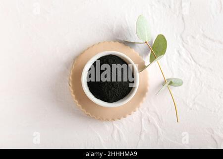 Schale mit aktivem Holzkohle-Zahnpulver auf weißem Hintergrund Stockfoto