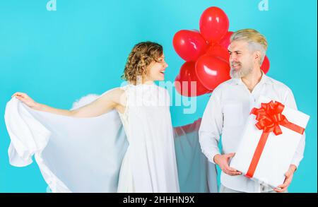 Geschenke zum Valentinstag. Paar in valentinstag mit Herz Ballons und Geschenk. Familienengel. Stockfoto