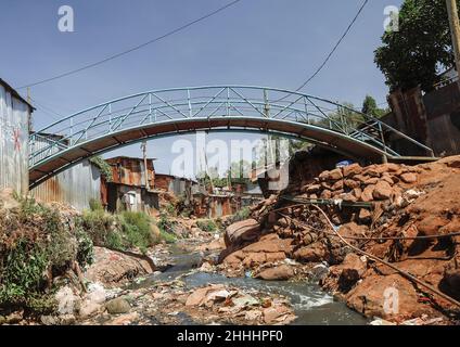 Nairobi, Kenia. 13th Januar 2022. Blick auf eine lokale Brücke, die sich durch einen lokalen Kanalfluss in den Slums von Kibera, Nairobi, trennt.in einem Zuhause, in dem jeder im Allgemeinen freundlich und erfreut ist, Menschen aus anderen Teilen der Welt und anderen Teilen der Welt zu treffen, Das Leben ist ein wenig überraschend, da die Gemeinschaft trotz der hohen Armutsrate und des Mangels an Arbeitsplätzen extrem glücklich ist. Eine Lebensader der Menschen, die in den Slums in den armen Wohnstrukturen leben, hängen stark von einkommensschwachen Arbeitsplätzen ab, um ihren täglichen Bedarf zu decken, und das ist nur möglich, wenn die Einheimischen von Dif kommen Stockfoto