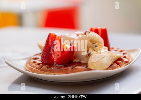 Köstlicher Pfannkuchen mit Eis und Früchten. Pfannkuchen-Dessert mit Erdbeeren und Süßigkeiten. Kolumbianische Küche. Stockfoto