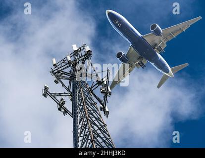 Mobilfunkmast mit 5G Frequenzen im C-Band mit Flugzeugen, die an Land kommen. Fluggesellschaften machten sich Sorgen über Störungen des Höhenmessers Stockfoto