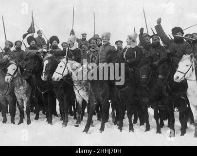 Das russische Weihnachten liegt zwölf Tage hinter uns, aber die Armeen bereiten sich bereits auf ihre Weihnachtsfeier auf dem Feld vor. Pakete und Pakete mit Waren kommen Monate vor der Übergabe im Außendienst von Petrograd an. Unser Bild zeigt eine Kosakenparty, die die Weihnachtsbefehlen des Hauptquartiers vom 25th. Dezember 1914 anfeuert Stockfoto