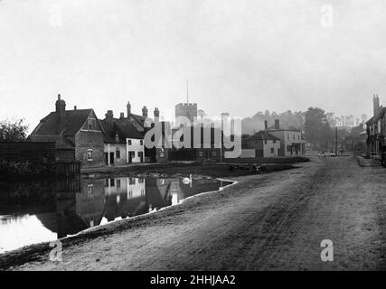 Kinder sitzen auf dem grünen Dorf Chalfont St. Giles und beobachten den Schwan auf dem Teich um 1900 Stockfoto