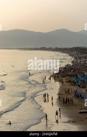 Blick auf den Sandstrand von Sperlonga und Touristen bei Sonnenuntergang, alte italienische Stadt in der Provinz Latina am Tyrrhenischen Meer, Touristen Urlaubsziel Stockfoto