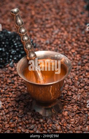 Zerkleinern Sie Kaffeemörtel und Stößel mit Kaffeebohnen Stockfoto