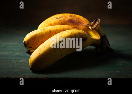 Bananenfrüchte auf einem Holztisch Stockfoto