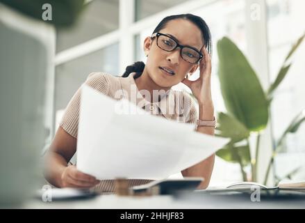 Das ist so kompliziert und verwirrend. Porträt einer jungen Geschäftsfrau, die gestresst aussieht, während sie in einem Büro die Finanzen berechnet. Stockfoto