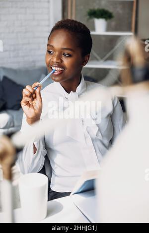 Porträt einer nachdenklichen afroamerikanischen Geschäftsfrau, die in ihrem Bürozentrum arbeitet. Stockfoto