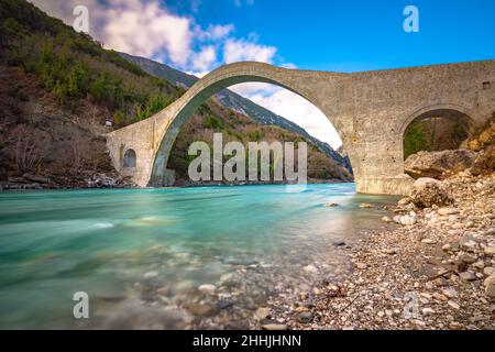 Die große gewölbte Steinbrücke von Plaka am Arachthos-Fluss, Tzoumerka, Griechenland. Stockfoto