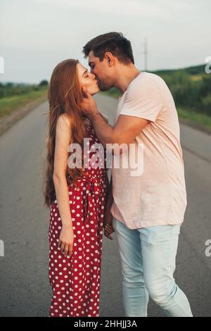 Seitenansicht eines kaukasischen Paares, das mitten auf der Straße steht und sich küsst. Wahre Liebe. Stockfoto