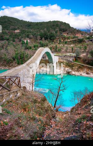 Die große gewölbte Steinbrücke von Plaka am Arachthos-Fluss, Tzoumerka, Griechenland. Stockfoto