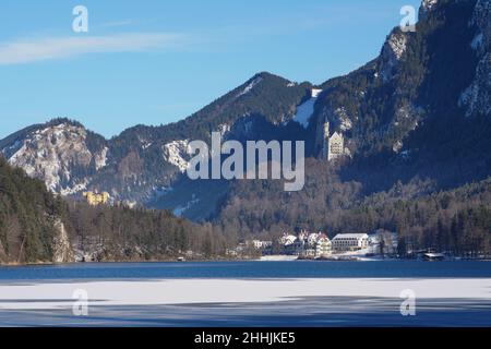 Blick im Winter vom teilweise eisbedeckten Alpsee auf das königliche Schloss Neuschwanstein von König Ludwig II. Stockfoto