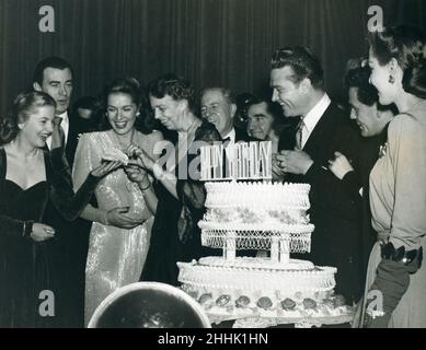 Washington, DC -- Geburtstagsfeier des FDR im Statler Hotel, 29. Januar 1944. First Lady Eleanor Roosevelt schenkt der Schauspielerin Joan Fontaine ein Stück Geburtstagstorte, während der Komiker Red Skelton, der Schauspieler John Garfield und andere darauf schauen. Foto: Abbie Rowe Stockfoto