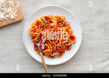 Blick von oben auf appetitliche hausgemachte Pasta mit Bolognese-Sauce serviert Mit frischen Basilikumblättern auf weißem Teller Stockfoto