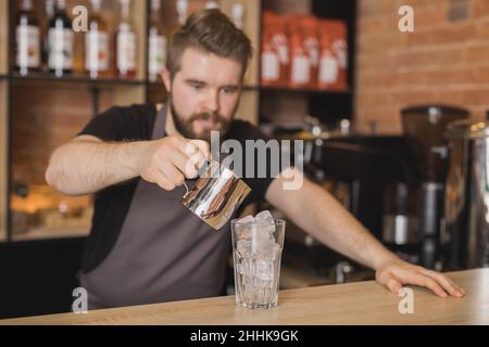 Junge Gärtnerin trägt grüne Pflanze während der Arbeit in Orangerie Stockfoto