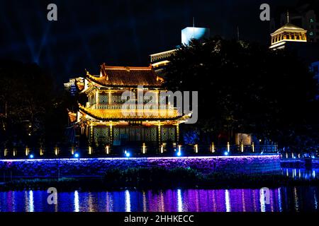 Traditioneller chinesischer Tempel bei Nacht mit Nachtlichtern und Fluss Stockfoto