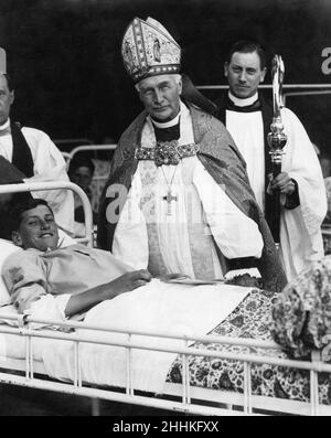 Der Bischof von London, Arthur Foley Winnington-Ingram, bestätigt einen von mehreren Jungen und Mädchen, die im Bett im Heritage Hospital, im Tide Mills, in East Sussex, Montag, 1st. Mai 1929. Stockfoto