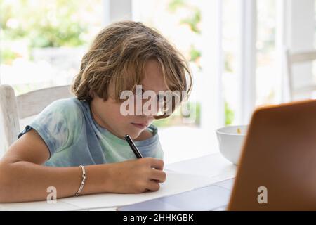 Junge (8-9) beim Zeichnen eines Bildes während des Online-Unterrichts Stockfoto