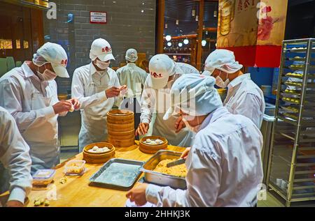 DUBAI, VAE - 7. MÄRZ 2020: Die Köche des asiatischen Restaurants der Dubai Mall arbeiten am März in offener Küche und bereiten Baozi-Knödel in Bambusdampfern zu Stockfoto