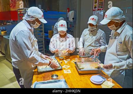 DUBAI, VAE - 3. MÄRZ 2020: Die Köche des orientalischen Restaurants der Dubai Mall arbeiten in offener Küche, sie machen Baozi-Knödel und legen sie dann in die Stockfoto
