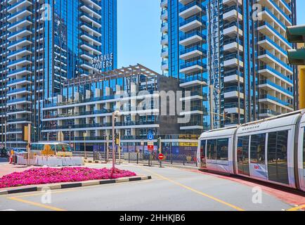 DUBAI, VAE - 7. MÄRZ 2020: Die moderne Straßenbahn fährt am 7. März in Dubai entlang des modernen Sparkle Towers-Komplexes in Dubai Marina Stockfoto