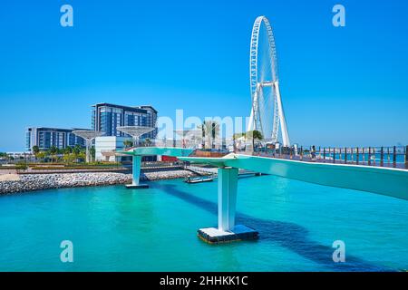 Die malerische Metallbrücke vor der Bluewaters Island mit modernen Wohngebäuden, Restaurants, Erholungszone und Ain Dubai Ferris Wheel, Stockfoto