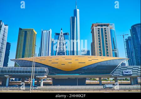 DUBAI, VAE - 7. MÄRZ 2020: DMCC Metro Station vor den gläsernen Wolkenkratzern des Jumeirah Lake Towers Viertels, am 7. März in Dubai Stockfoto