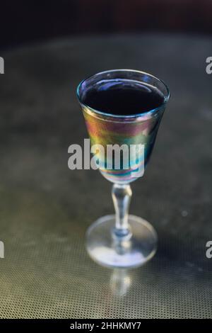 Schillerndes schwarzes Limonade-Cocktailgetränk am Abend mit goldenem Messingtisch Stockfoto