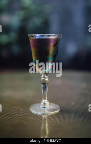 Schillerndes schwarzes Limonade-Cocktailgetränk am Abend mit goldenem Messingtisch Stockfoto