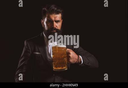 Bierkneipen und Bars. Mann mit Bierkrug. Fröhlicher Brauer, der Glas mit Bier hält. Stockfoto