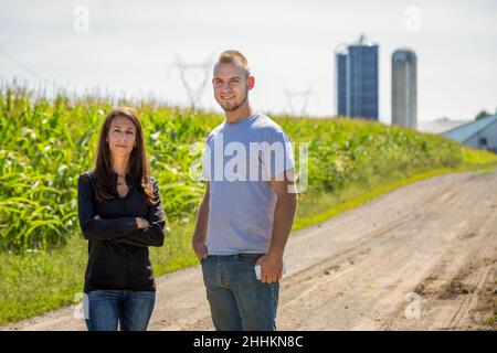 Ein stolzes Paar landwirtschaftlicher Unternehmer, das in einem Maisfeld auf die Kamera schaut. Hochwertige Fotos Stockfoto