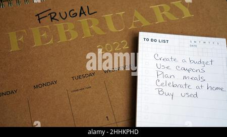 Sparsamer Februar auf dem Kalender zusammen mit einer Liste von Tipps geschrieben. Die Idee hinter Frugal February ist, zu versuchen, so billig wie möglich zu leben. Stockfoto