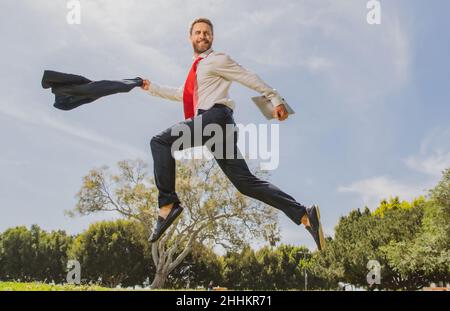 Geschäftsmann im Anzug, der über den Stadtpark springt. Schnelles Geschäftskonzept. Stockfoto