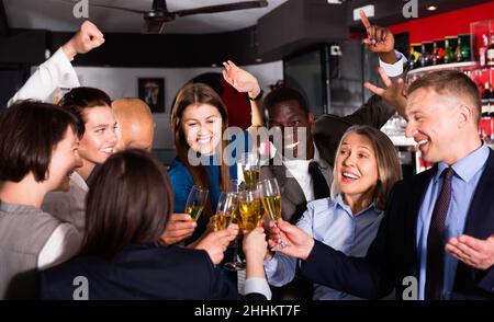 Internationale Gruppe von Geschäftsleuten, die mit Champagner toasten und sich auf der Büroparty im Nachtclub amüsieren Stockfoto