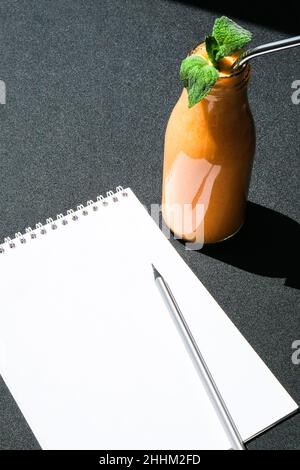 Saisonale Kürbis Karotten Smoothie Getränk Detox mit Bio-Metall Trinkhalm. Glasflasche mit orangefarbenem Smoothie. Platz für Papiernotiz-Kopien. Sauberes Essen Stockfoto