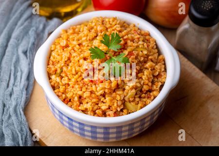 Traditioneller türkischer Bulgur-Pilaf mit Tomatensoße auf dem Teller (türkischer Name; Meyhane pilavi) Stockfoto