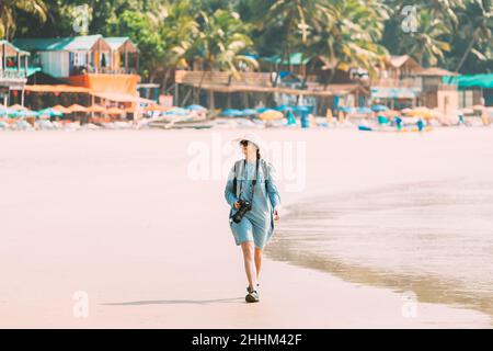 Canacona, Goa, Indien. Junge Kaukasische Frau Mit Kamera, Die Am Palolem Beach Entlang Der Küste Im Sommer An Sonnigen Tagen Spazierengeht Stockfoto